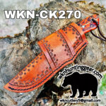 Orange tooled leather knife sheath laid on a tree trunk, with bold 'WKN-CK270' text and a black bear silhouette watermark near the bottom.