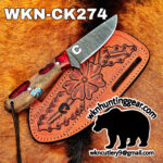 Damascus blade knife on a tooled orange leather sheath over a rustic fur background, displaying the model number WKN-CK274.