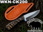 Hunting knife with a textured dark handle and bright steel blade beside a brown leather sheath outdoors on dirt, with branding text 'WKN-CK290' and a bear logo and email address in the corner.