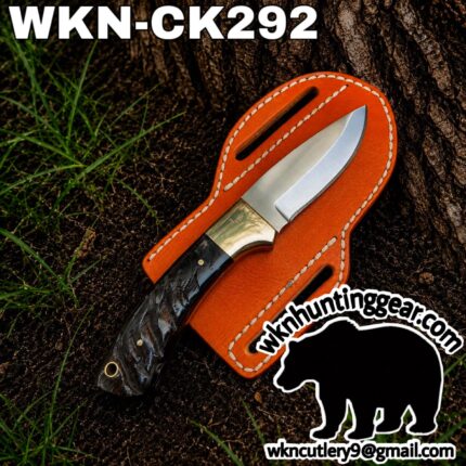 Fixed-blade knife with a dark textured handle resting on an orange leather sheath beside a tree, with the text 'WKN-CK292' across the top and a black bear silhouette logo and email watermark reading wk cutlery9@gmail.com.