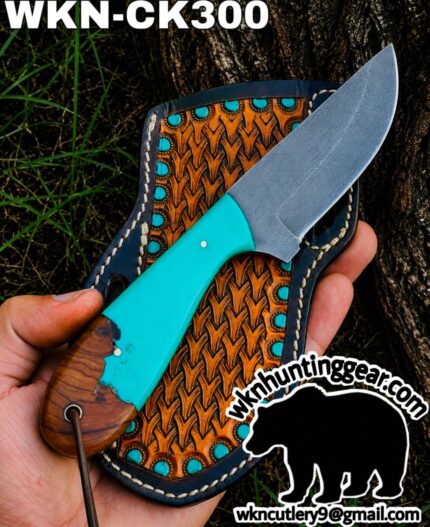 Turquoise-handle fixed-blade knife laid on a decorative brown leather sheath outdoors, with WKN-CK300 text visible in the corner.