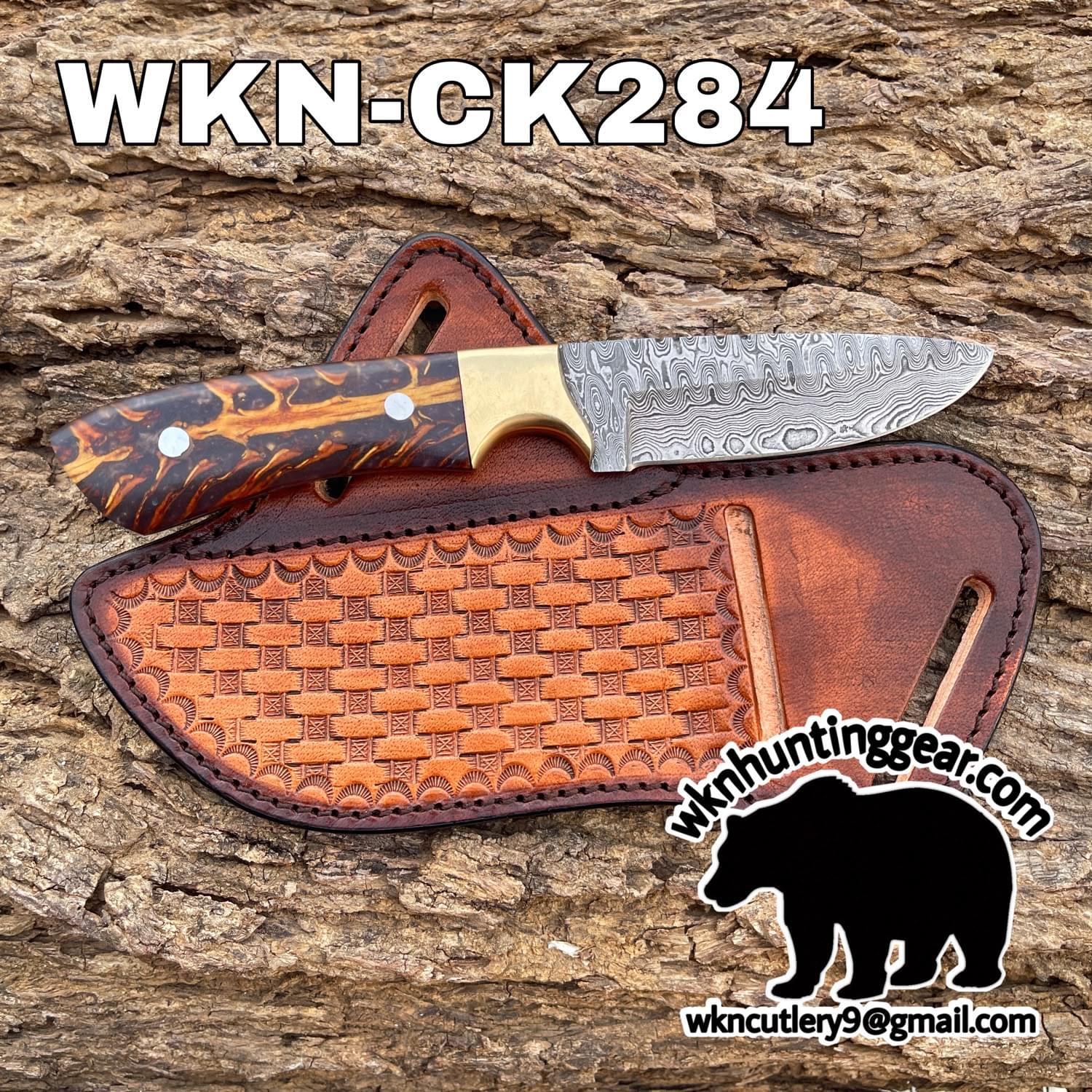 Damascus-pattern knife with a swirling metal blade and wood/grain handle resting on a leather sheath against a tree bark background.