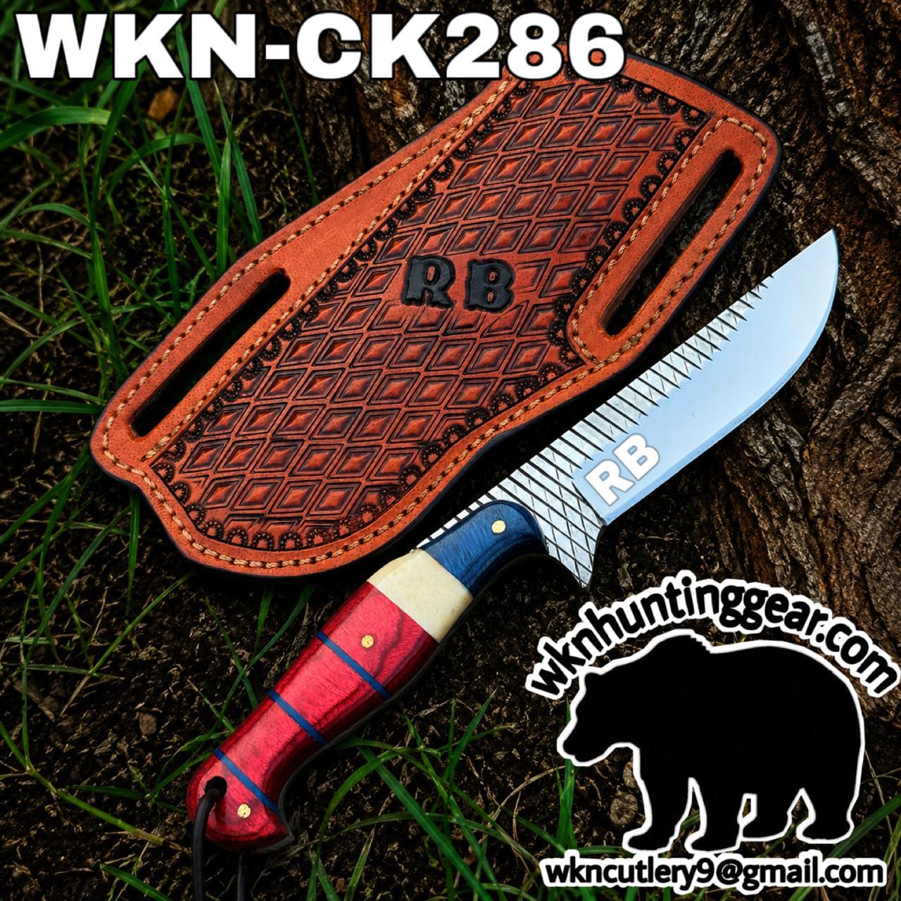 RB branded fixed-blade knife with a patterned steel blade and red-blue handle beside a brown leather sheath on a tree stump; outdoors.