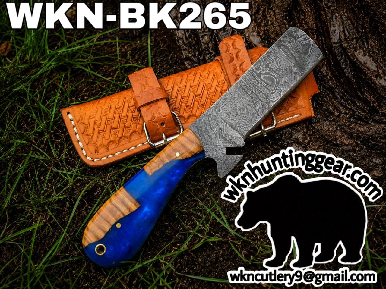 Damascus fixed-blade knife with a blue and wood handle resting on a brown leather sheath outdoors; labeled WKN-BK265 with the wk hunting gear logo and bear graphic in the corner.