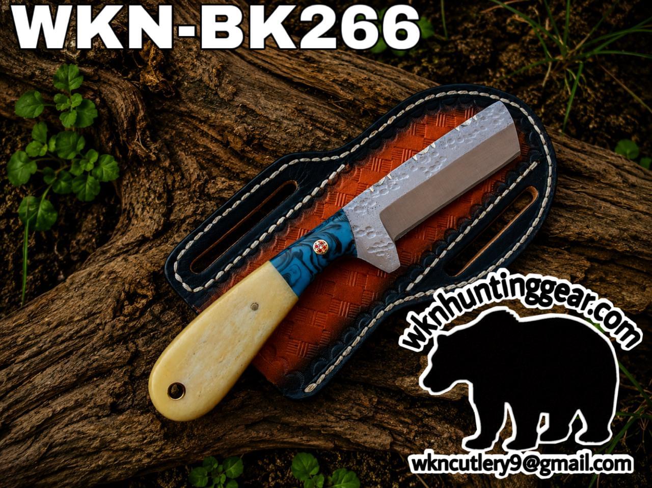 Fixed-blade knife with a blue-patterned handle resting in a brown leather sheath on a log; watermark shows wknhuntinggear.com in the corner.