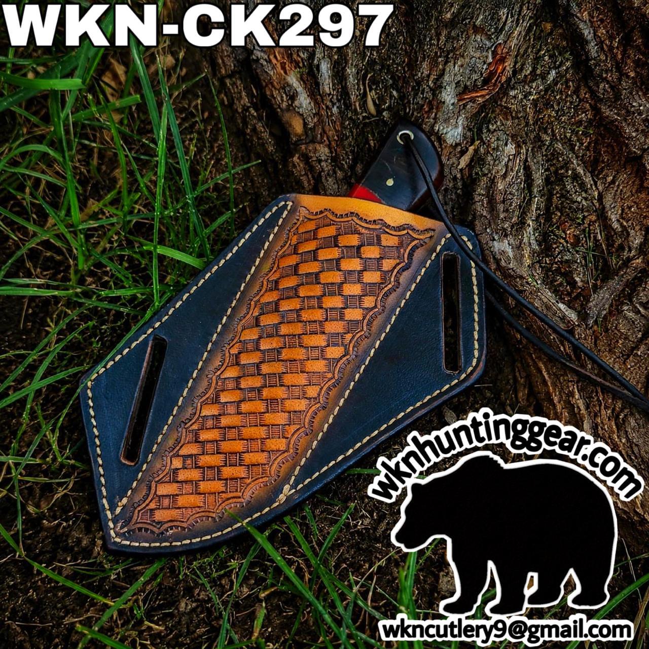 Leather knife sheath with an orange woven panel on blue leather, resting against a tree trunk; branding text and a bear watermark overlay the image.