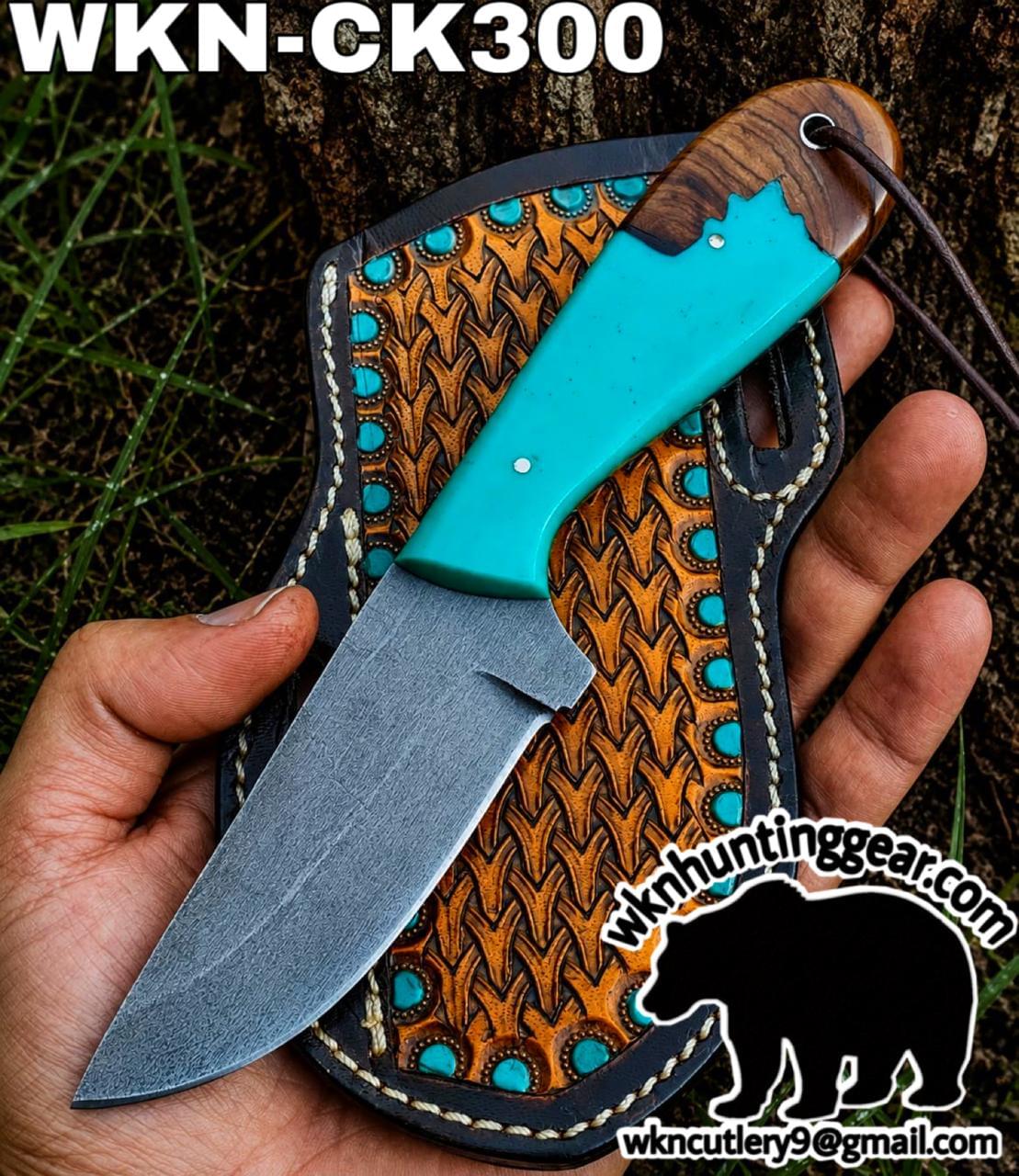 Hunting knife with a turquoise handle resting on a patterned leather sheath outdoors.','Turquoise-handled knife displayed on a decorative leather sheath with turquoise studs.','A fixed-blade knife with a bright turquoise handle placed on a textured leather sheath with turquoise accents.','Close-up of a turquoise-handle knife on its leather sheath, outdoors (brand watermark visible).','Outdoor hunting knife shown on its patterned sheath, featuring a teal handle and rugged leather details.
