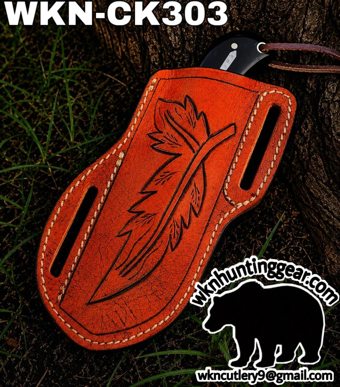 Orange leather knife sheath with a carved leaf design, laid on tree bark outdoors (WKN-CK303).