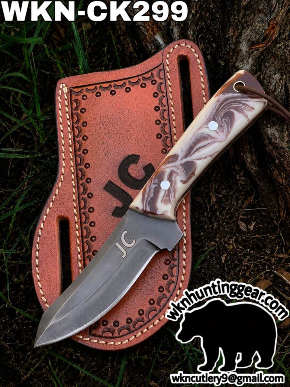 Fixed-blade knife with marbled brown handle resting on a stitched leather sheath outdoors. Includes watermark "wkhuntinggear.com" and email.